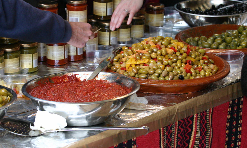 Harissa und Oliven in einem Souk in Marokko